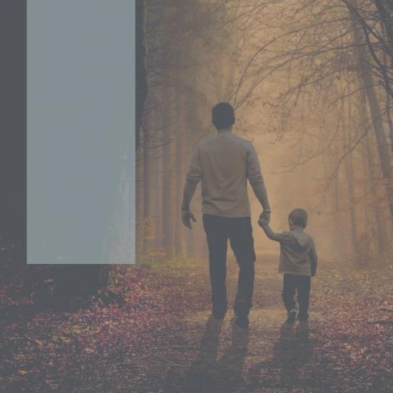 En mand med et barn i hånden ses bagfra