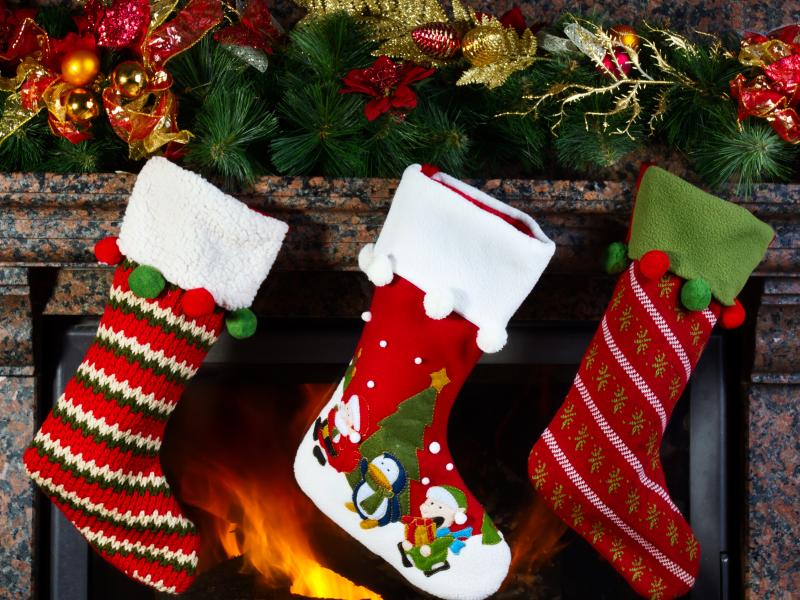 tre julesokker foran kamin med julepynt